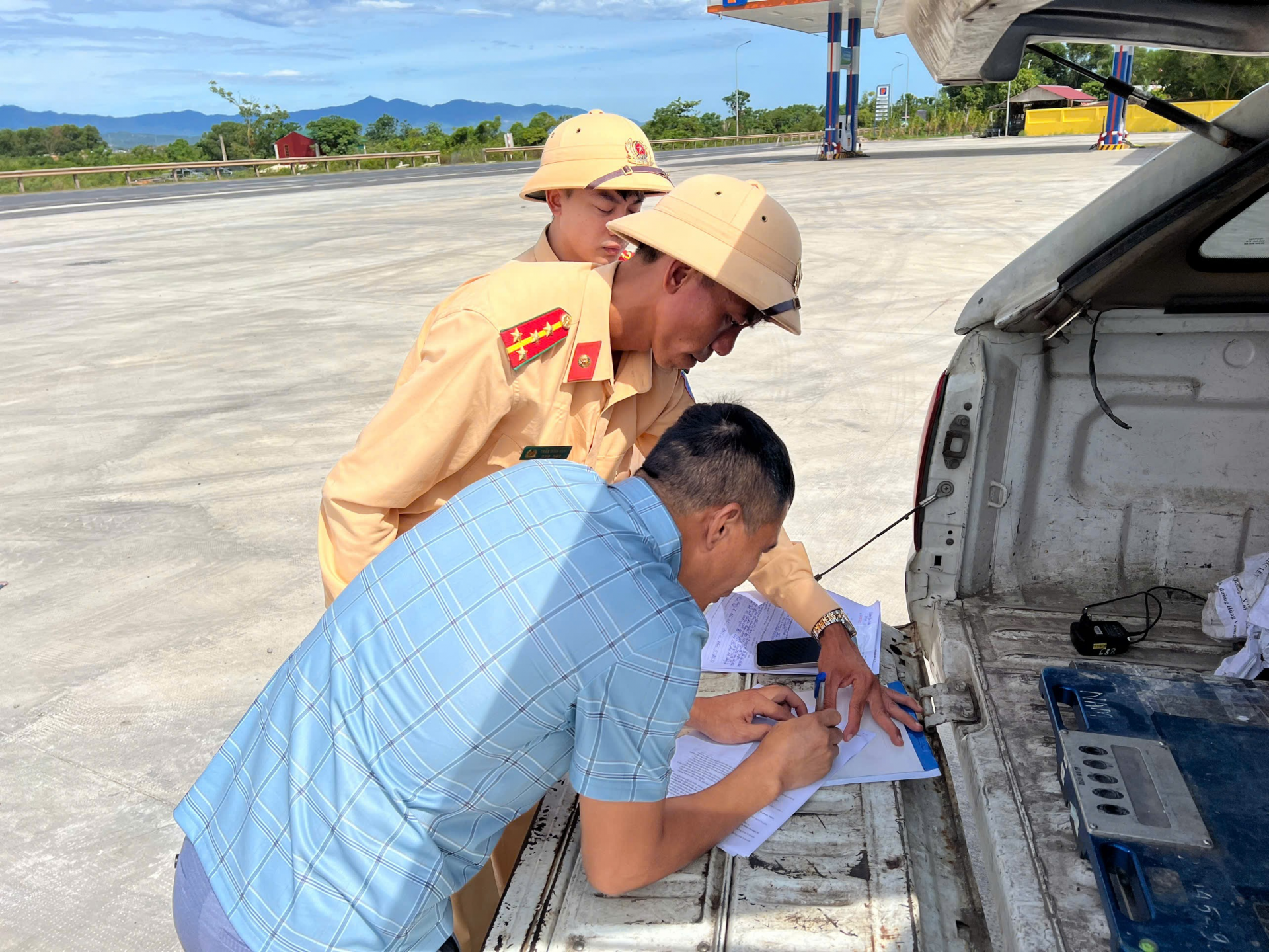 Tài xế kí biên bản vi phạm hành chính. Ảnh: Hoàng Anh