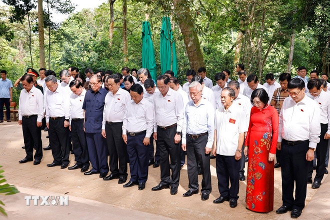 Chủ tịch Quốc hội Trần Thanh Mẫn và nguyên Tổng Bí bí thư Nông Đức Mạnh và đại biểu dâng hương, dâng hoa tưởng nhớ Chủ tịch Hồ Chí Minh tại Lán Nà Nưa. (Ảnh: TTXVN)