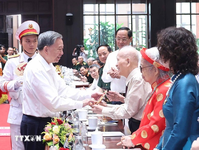   Tổng Bí thư Tô Lâm tặng quà cho cán bộ lão thành cách mạng. (Ảnh: TTXVN)